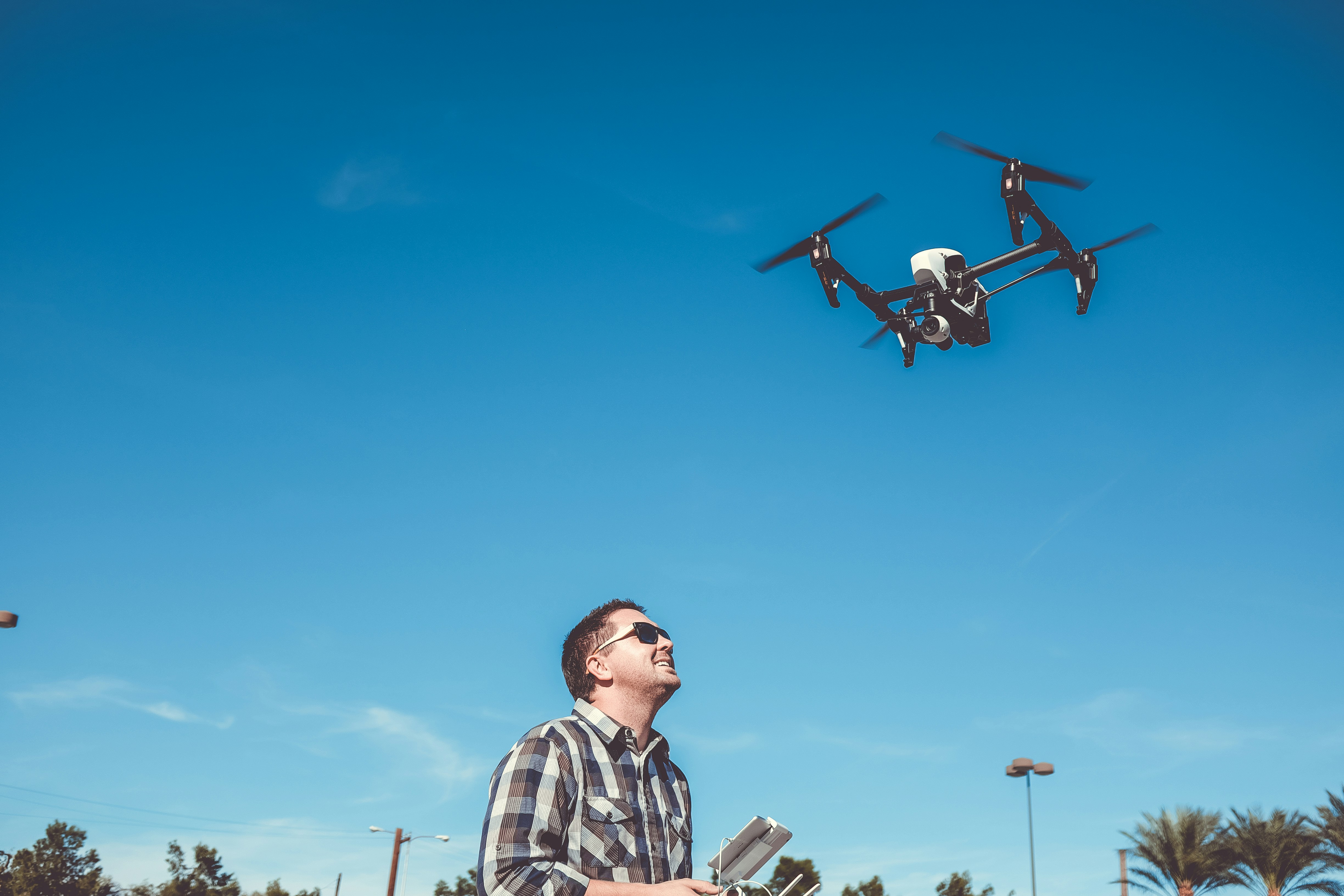 Man With Remote Control And Flying Drone